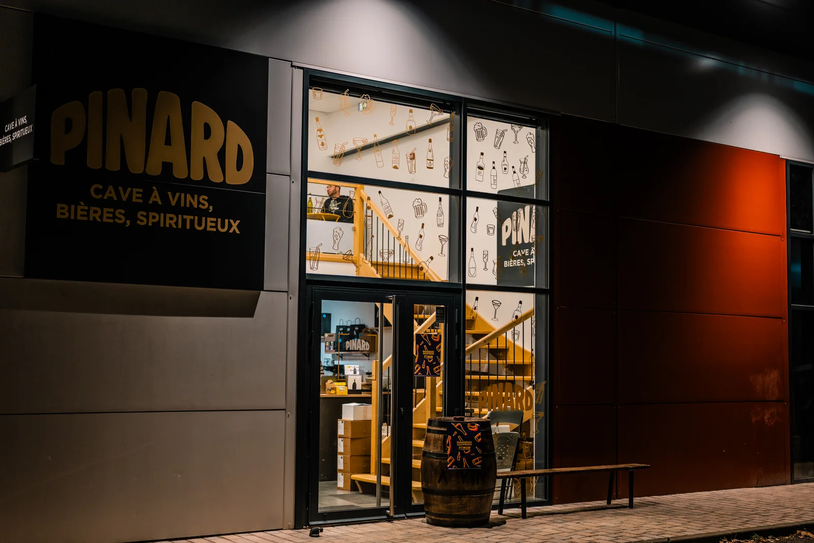 La devanture éclairée d’une cave à vins photographiée à la tombée de la nuit.
