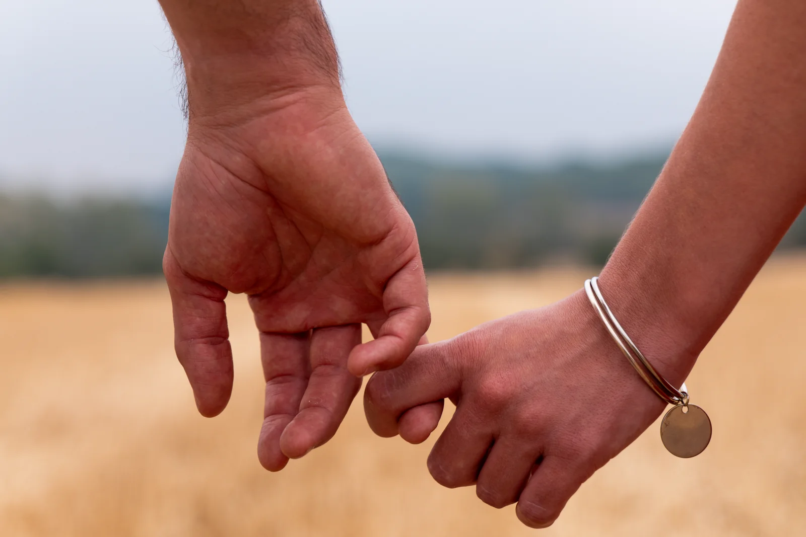 Les mains des futurs parents se cherchent dans un geste complice.