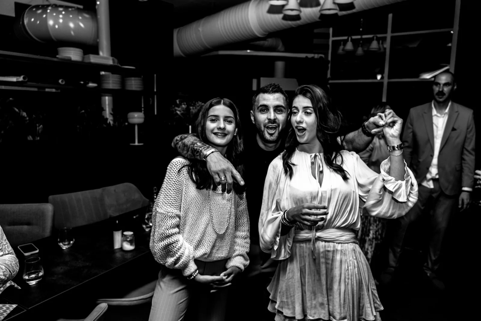 Un groupe d’amies célèbre la soirée face à l’objectif, en noir et blanc.